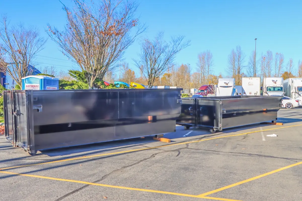 Professional dumpster rental service with roll-off container on residential driveway in Lock Haven